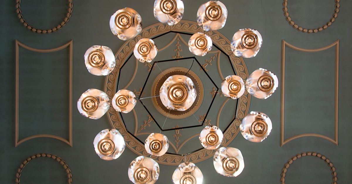 A top-down view of an intricate chandelier and ornate ceiling design, showcasing classic elegance.