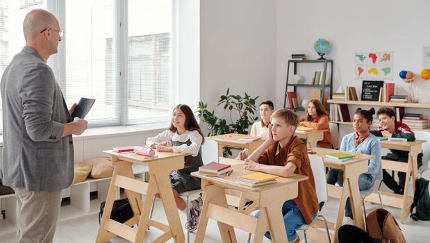 A teacher conducting a lesson in a diverse, engaging classroom with attentive students.