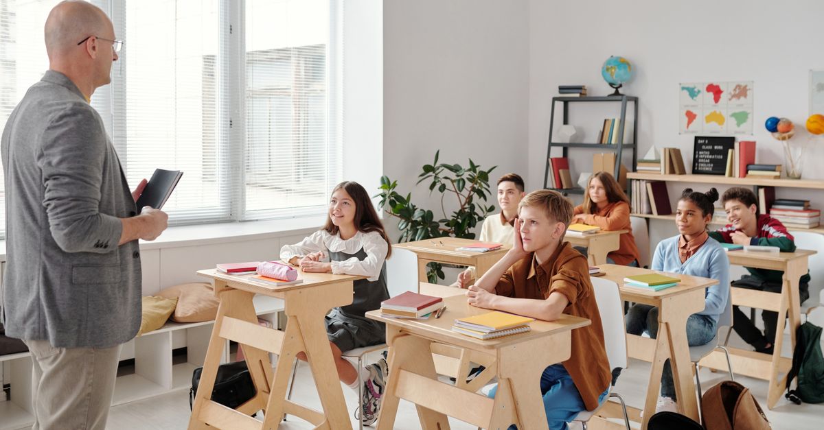A teacher conducting a lesson in a diverse, engaging classroom with attentive students.