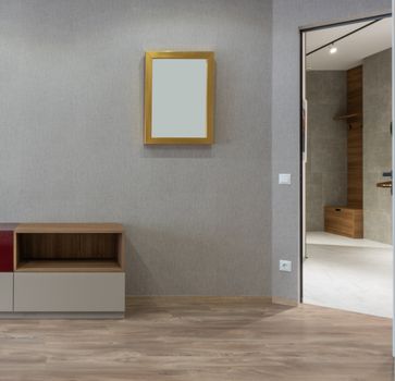 Spacious contemporary new apartment room with empty shelves and rectangular mirror on gray walls
