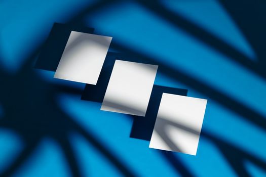 Modern abstract composition of white paper sheets casting shadows on a vivid blue background.