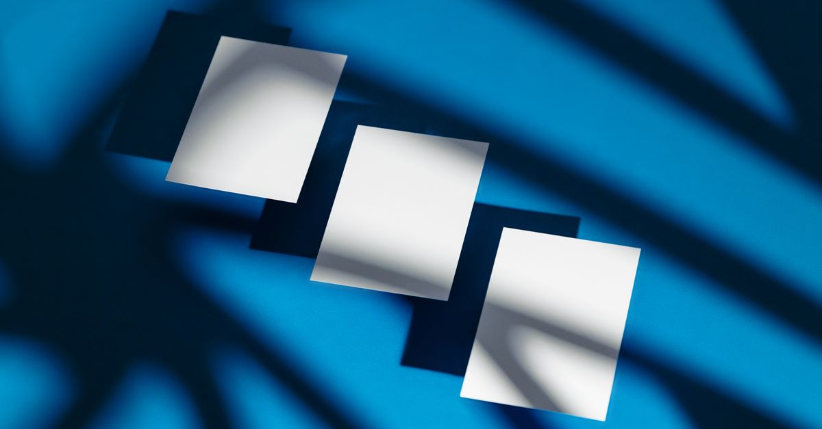 Modern abstract composition of white paper sheets casting shadows on a vivid blue background.