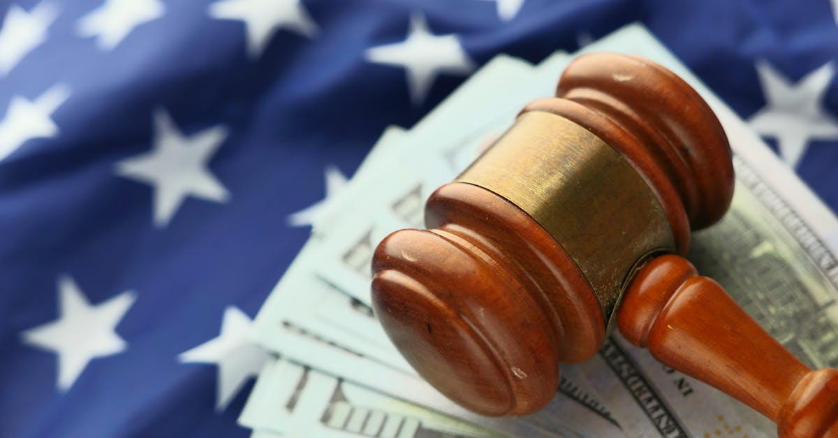 Close-up of a gavel on US dollar bills with American flag backdrop symbolizing justice and finance.