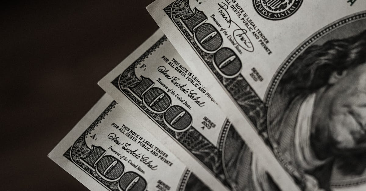 Detailed close-up image of US hundred dollar bills arranged in a fanned pattern.