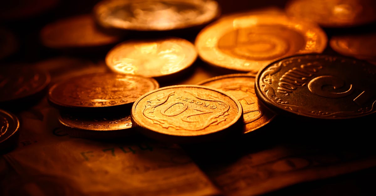 A detailed close-up of various coins illuminated with warm lighting, symbolizing wealth and savings.