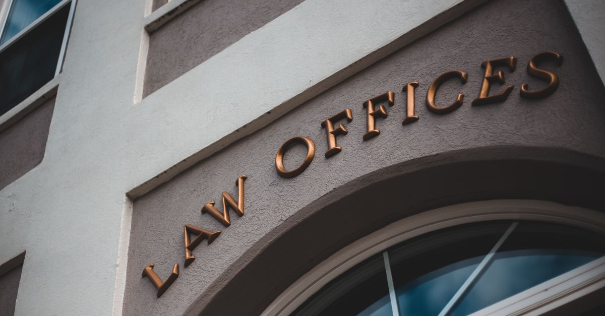 Low angle view of a modern law office exterior with elegant facade and arched entrance.