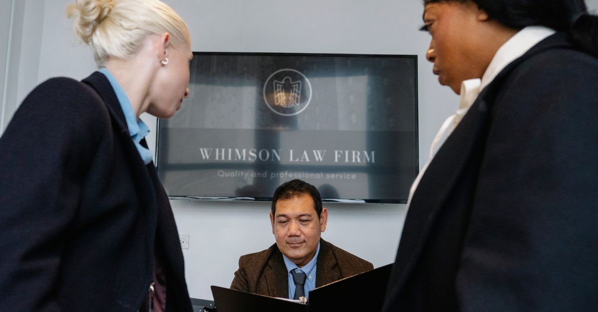 Diverse colleagues gathering in conference hall of law firm and discussing details of contract while working together