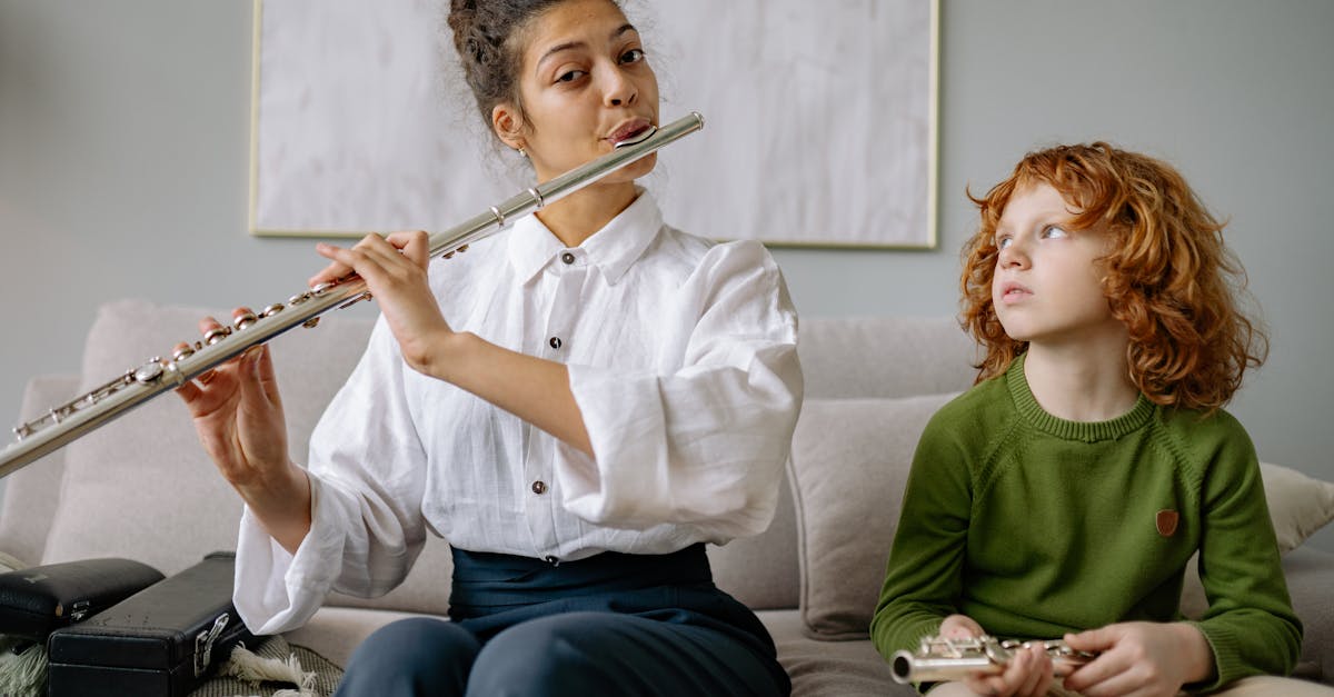 A woman teaches a boy flute lessons at home, focusing on musical instruction.