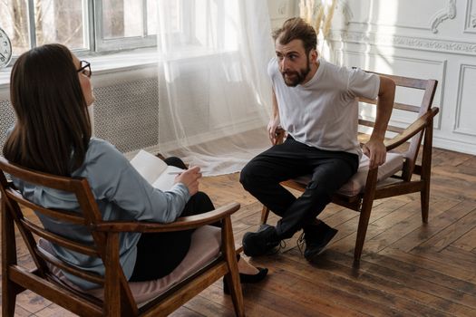 A therapist engages with a male patient in a counseling session.