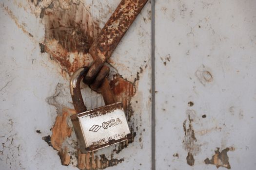 Detailed shot of a rusty padlock on a weathered door conveying security and time passage.