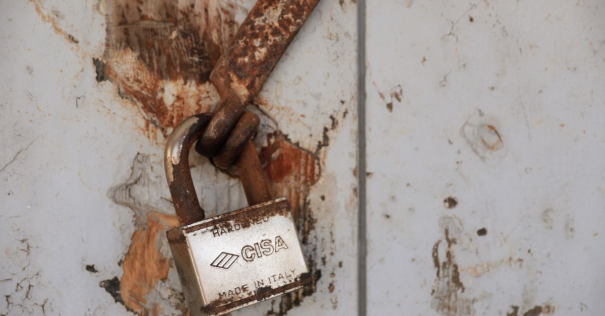 Detailed shot of a rusty padlock on a weathered door conveying security and time passage.