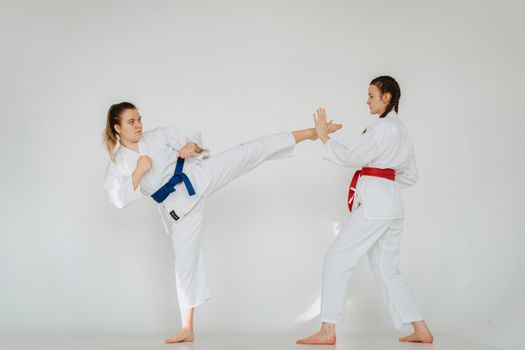 Dynamic shot of two women practicing martial arts techniques in a studio setting.