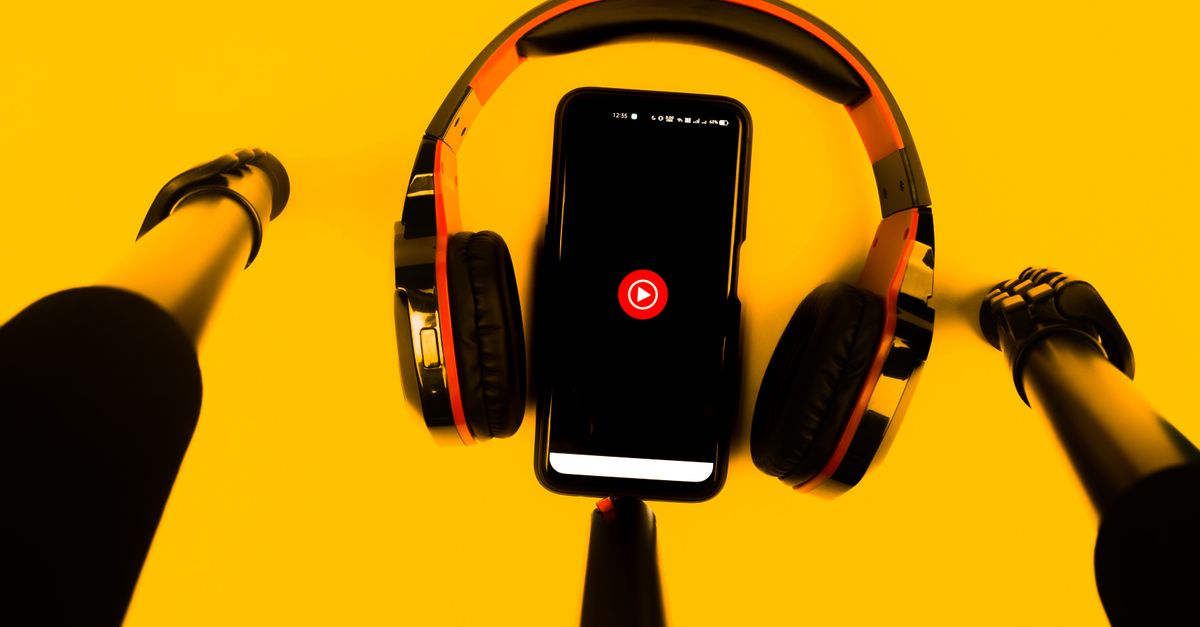 A smartphone with wireless headphones and microphone set against a vibrant yellow background.