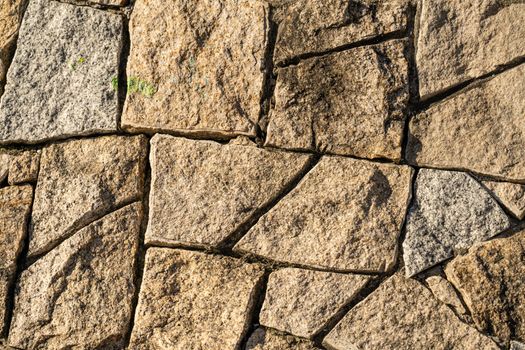 Close-up of textured natural stone wall surface, ideal for backgrounds.