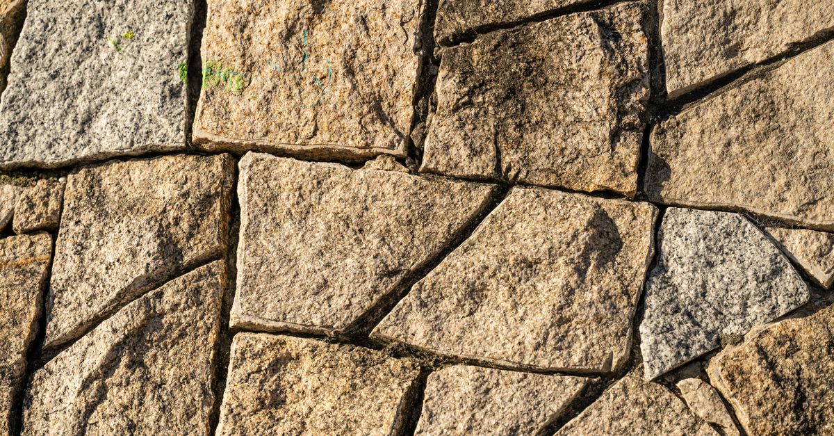 Close-up of textured natural stone wall surface, ideal for backgrounds.