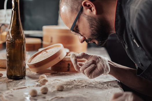 A chef inspects a dough ball on a flour-dusted counter, emphasizing precise food preparation.