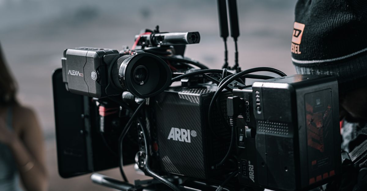 Close-up of a professional filmmaking camera setup on an outdoor set with blurred background.