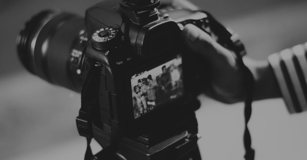 Black and white image of a DSLR camera capturing people in focus, showcasing photography professionalism.