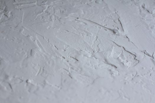 Close-up shot of a textured white plaster surface with rough details.