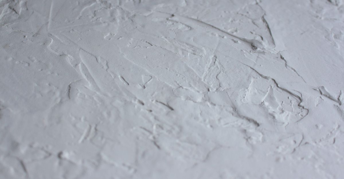 Close-up shot of a textured white plaster surface with rough details.