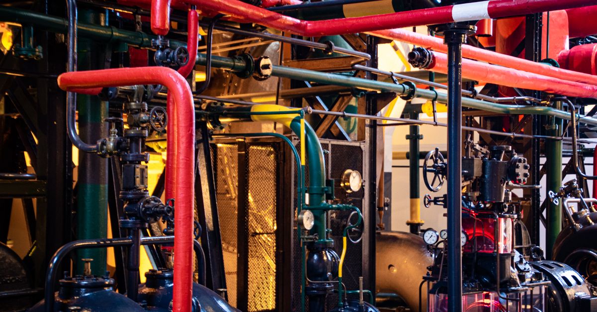 Complex network of industrial pipes and machinery inside a Lisbon plant.
