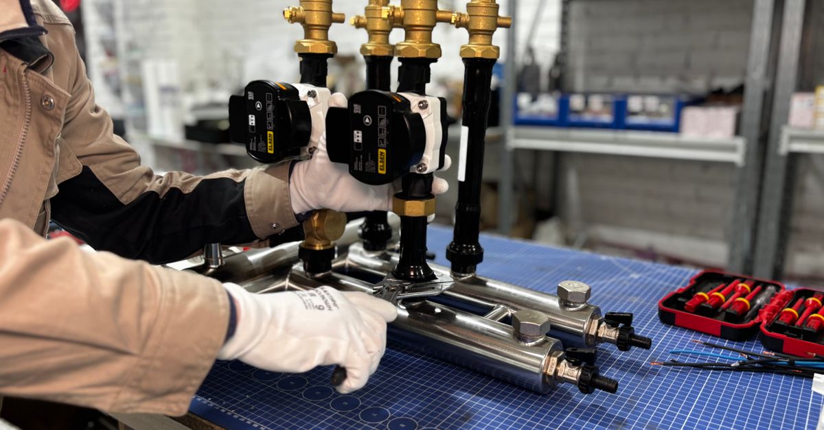Engineer assembling a piping system for industrial heating, featuring valves and control units.