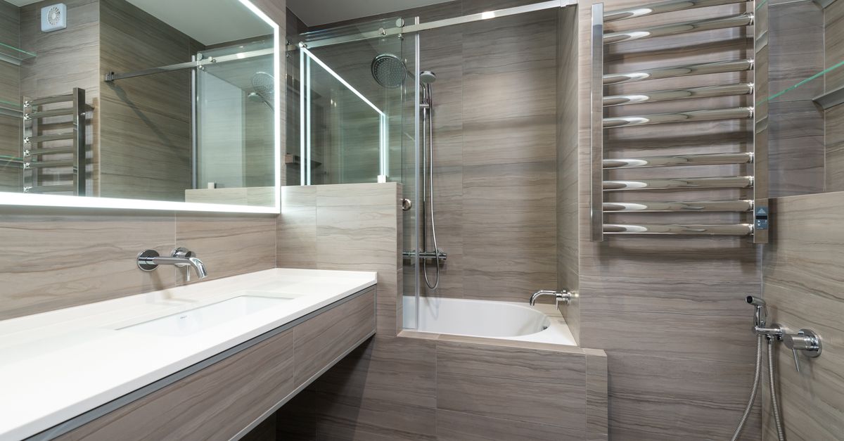 Elegant modern bathroom featuring a bathtub, shower, and sleek stainless steel fixtures.