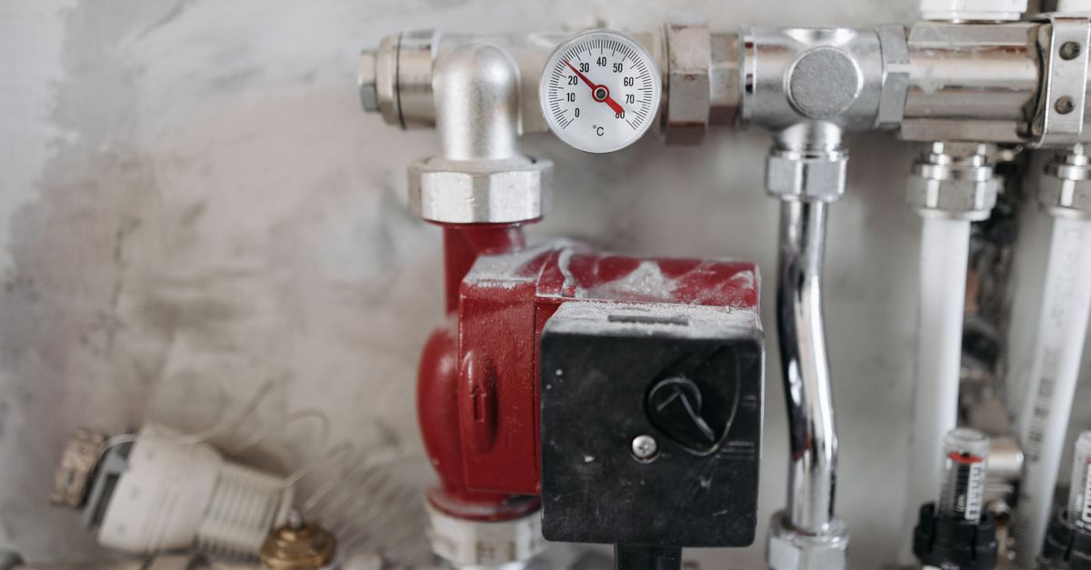 Close-up view of an industrial plumbing system featuring a pressure gauge and steel pipes.