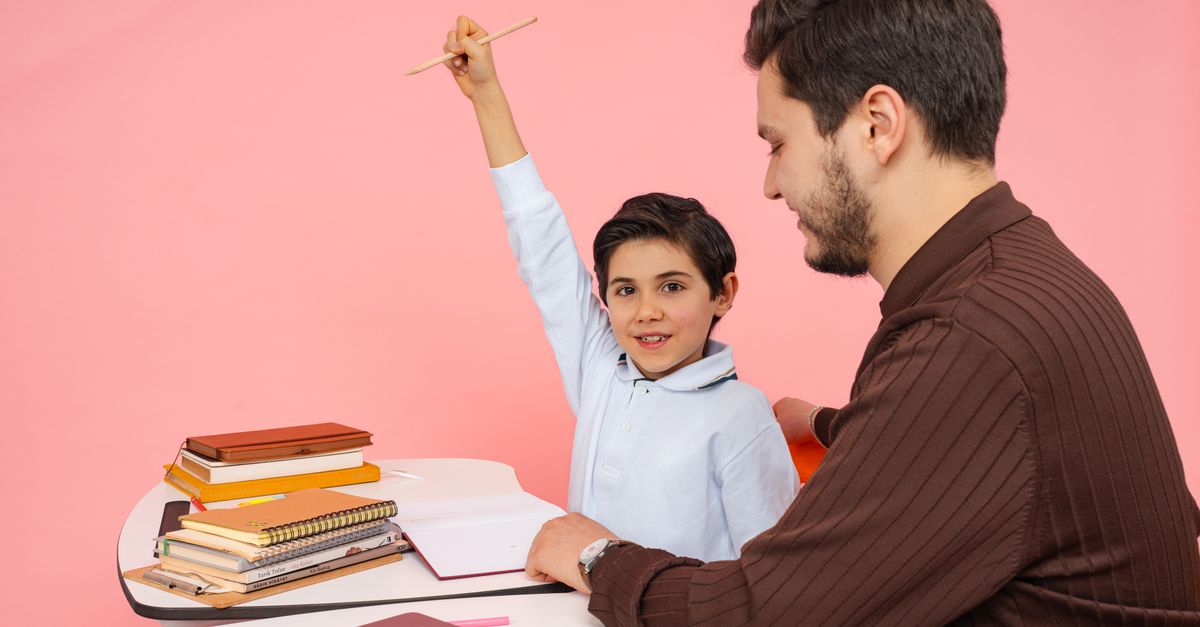 Teacher aids enthusiastic student in classroom setting, enhancing learning experience.