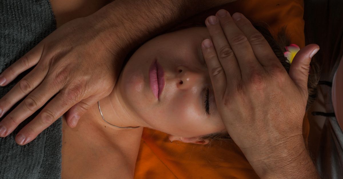 A serene close-up of a woman receiving a reiki massage for ultimate relaxation and wellness.