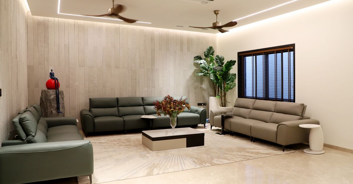 Spacious modern living room featuring green sofas, indoor plants, and minimalistic decor.