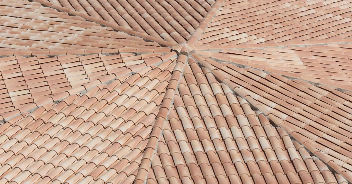 Detailed view of terracotta roof shingles forming a geometric pattern from above.