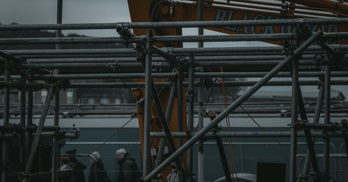 Scaffolding and machinery in an industrial setting with people in the background in Edinburgh, Scotland.