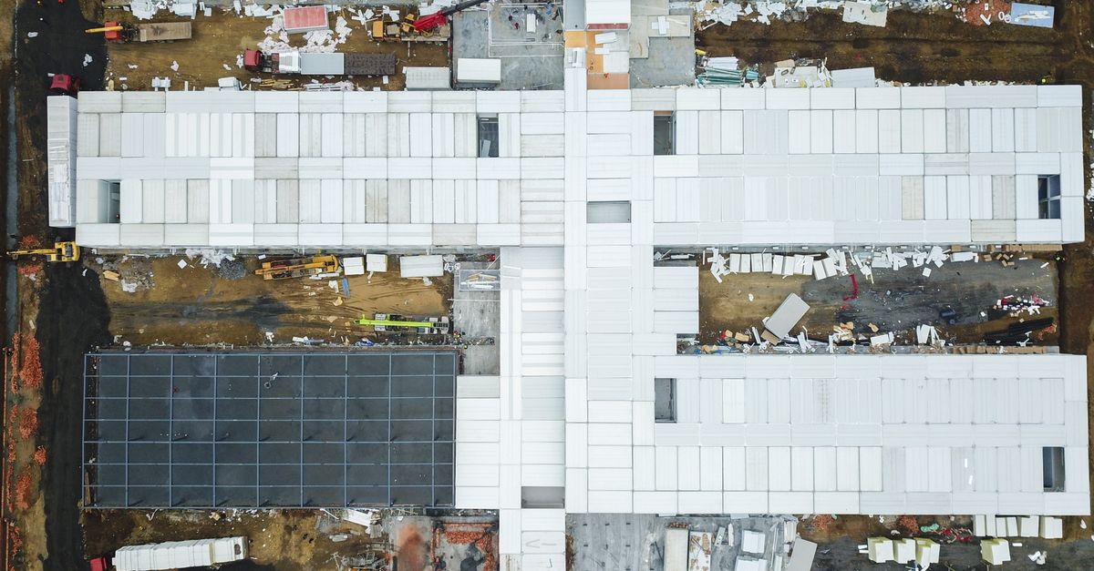 Drone shot capturing aerial view of a large construction site with unfinished buildings.
