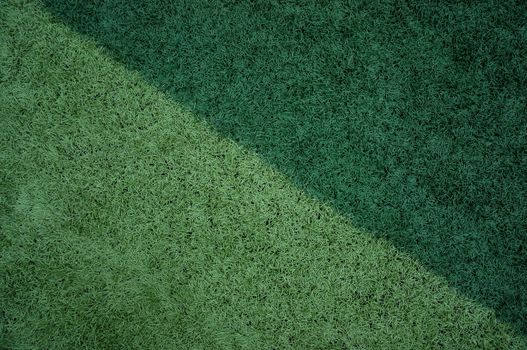 Close-up of a vibrant green grass surface with contrasting tones for design backgrounds.