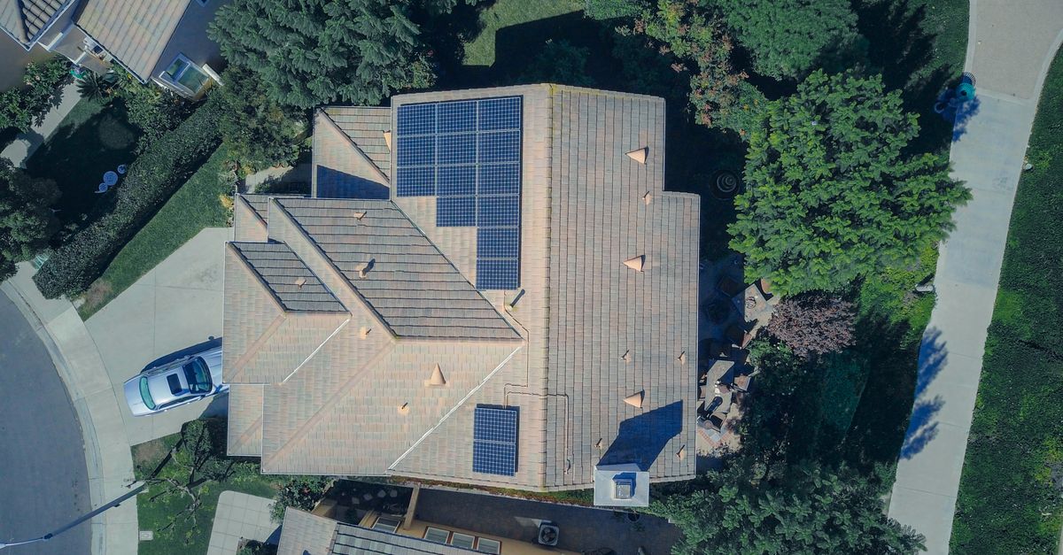 Top-down aerial view of a house with solar panels, showcasing modern renewable energy solutions.