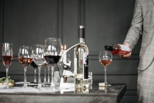 Close-up of a wine tasting session with a sommelier pouring rosé into a glass.