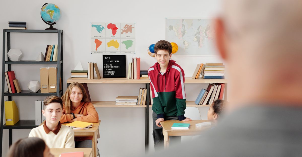 Students attentively listening in a classroom environment, promoting learning and engagement.