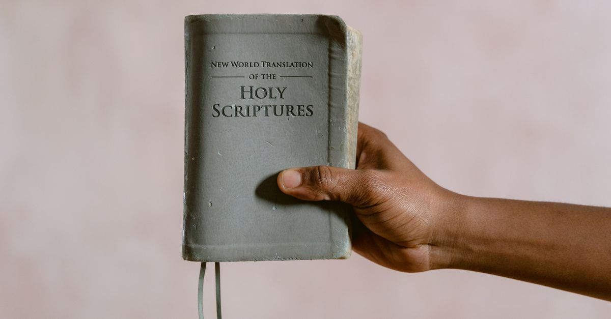 Close-up image of a hand holding the New World Translation of the Holy Scriptures book.