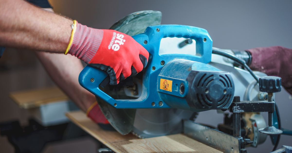 Carpenter using a circular saw to cut wood, showcasing precision craftsmanship.