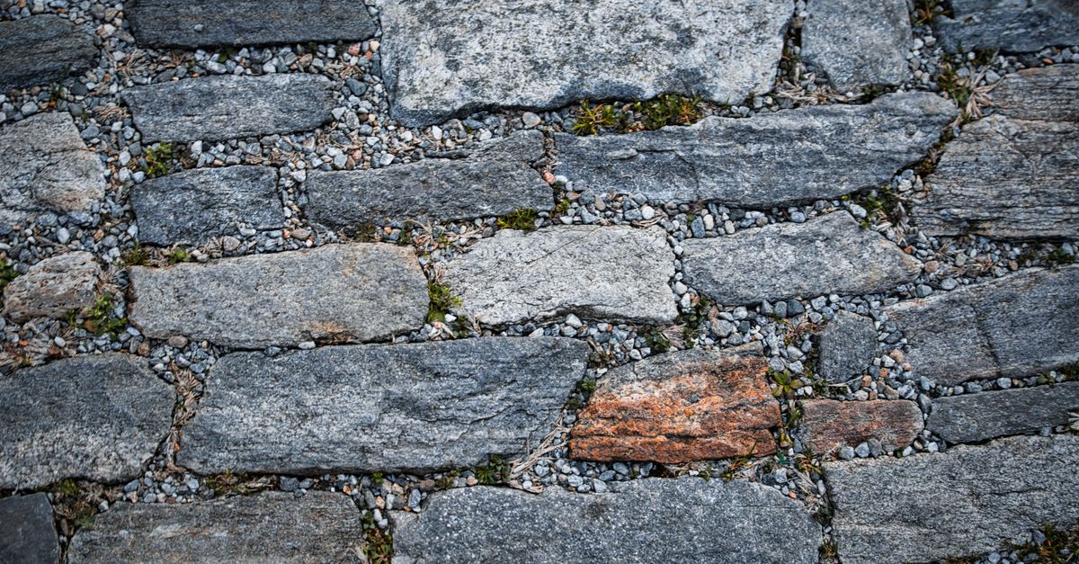 Close-up of weathered stone pavement showcasing textured natural rock formations and earthy tones.