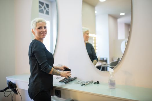 A hair stylist in a modern salon in Portugal with tools and a mirror.
