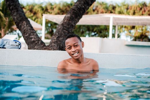 A happy man enjoying a relaxing swim in an outdoor pool during summer.