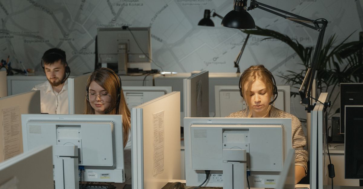 Call center agents working diligently with computers and headphones, providing customer support.