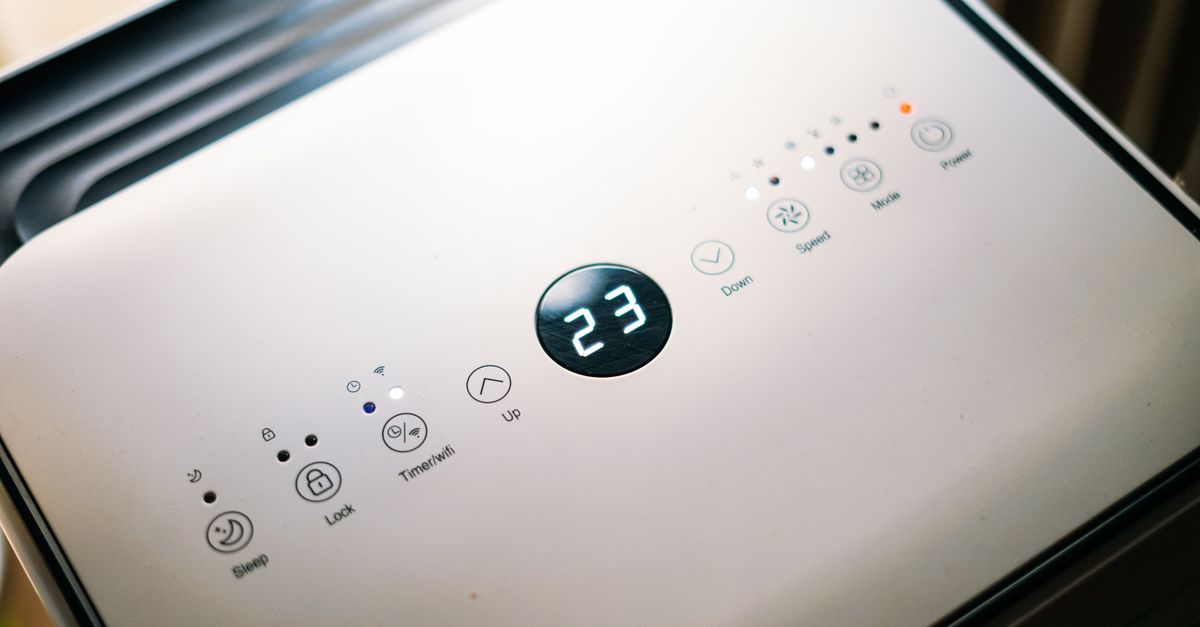 Close-up of a sleek air conditioner control panel displaying temperature.