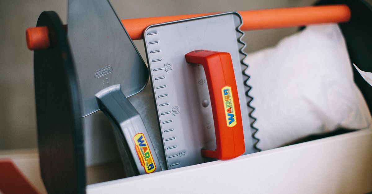 Vibrant plastic toy toolkit featuring trowel and square. Perfect for imaginative play.