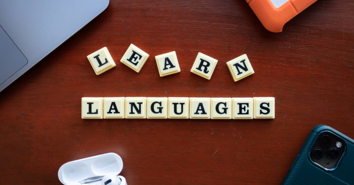 Flat lay of language learning materials with gadgets promoting education.