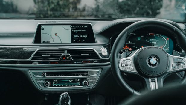 Close-up of a luxury car's steering wheel and dashboard with GPS display, showcasing a modern vehicle's interior features.