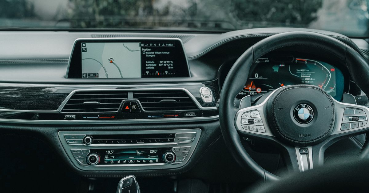 Close-up of a luxury car's steering wheel and dashboard with GPS display, showcasing a modern vehicle's interior features.