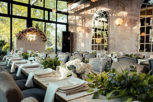 Beautifully decorated indoor wedding reception with flowers and elegant table settings.